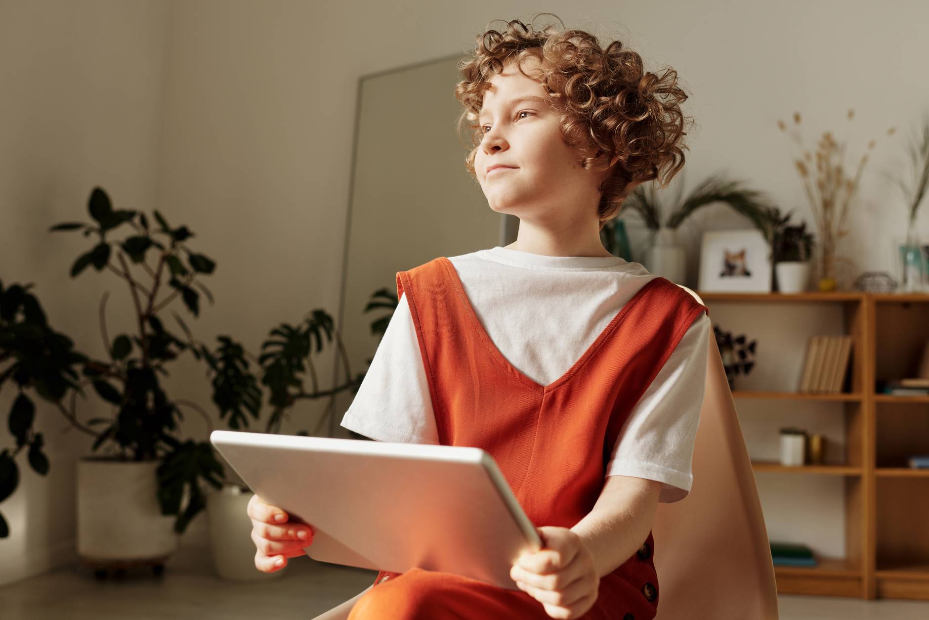 photo of young girl with red hair looking into the light and holding a laptop